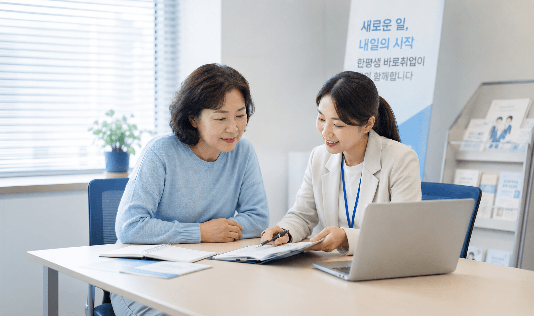 한평생 바로취업 상담 창구에서 상담사와 나란히 앉아 안내 책자를 보는 중년 여성
